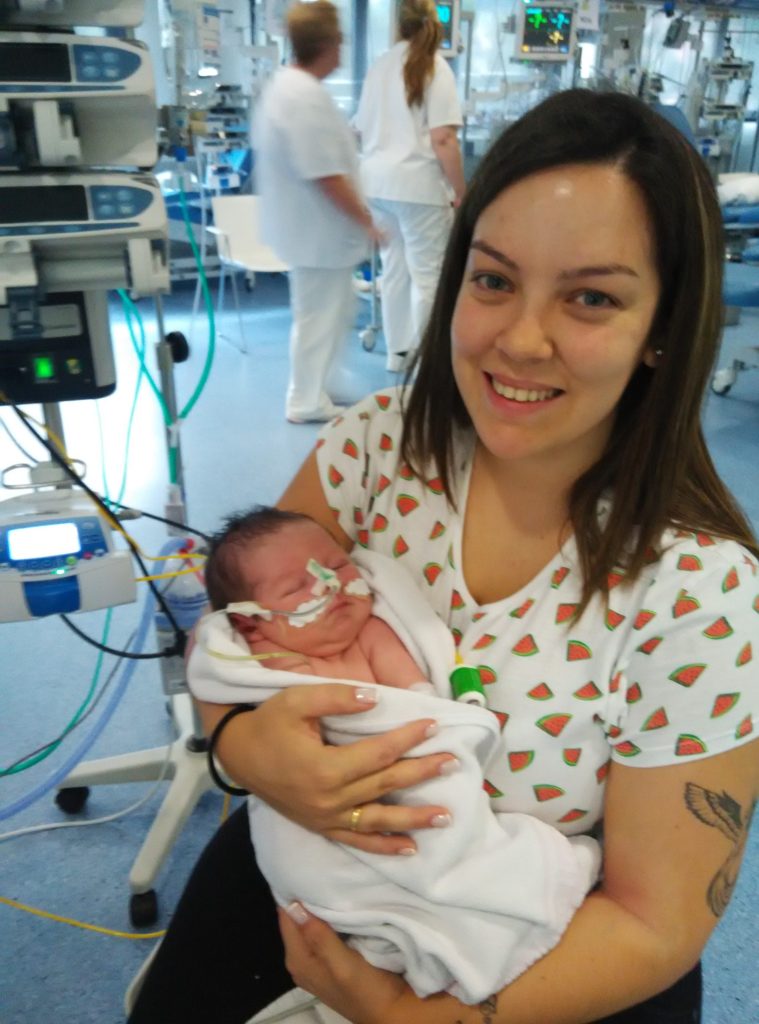 Éric en brazos de su madre en el hospital